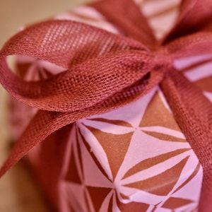 A parcel wrapped with Brick ribbon and Windmill Nougat paper by Cambridge Imprint