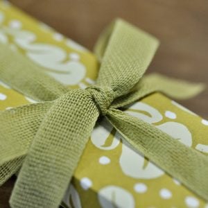 A parcel wrapped with Chartreuse ribbon and Quercus Sap Green paper by Cambridge Imprint
