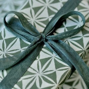 A parcel wrapped in Cypress ribbon and Windmill Kraken paper by Cambridge Imprint