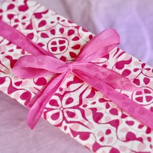 A parcel wrapped in Fuchsia ribbon and Dappled Eton Mess paper by Cambridge Imprint