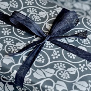 A parcel wrapped in Indigo ribbon and Small Ivy Stripe Blackthorn paper by Cambridge Imprint