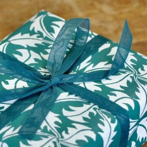 A parcel wrapped in Jade ribbon and Dandelion Bottle Green paper by Cambridge Imprint