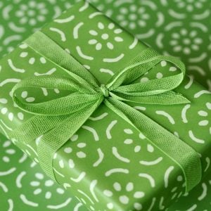 A parcel wrapped in Kiwi ribbon and Pear Halves Grass Green paper by Cambridge Imprint