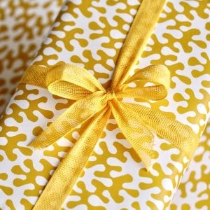 A parcel wrapped with Marigold ribbon and Kelp Boiled Egg paper by Cambridge Imprint