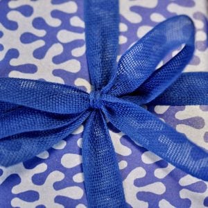 A parcel wrapped with Navy ribbon and Kelp Blueberry paper by Cambridge Imprint