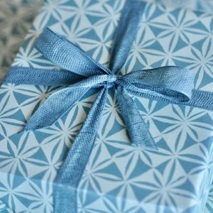 A parcel wrapped with Teal ribbon and Windmill Luskentyre paper by Cambridge Imprint