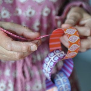 Making patterned paper chain in pinks, oranges and blues